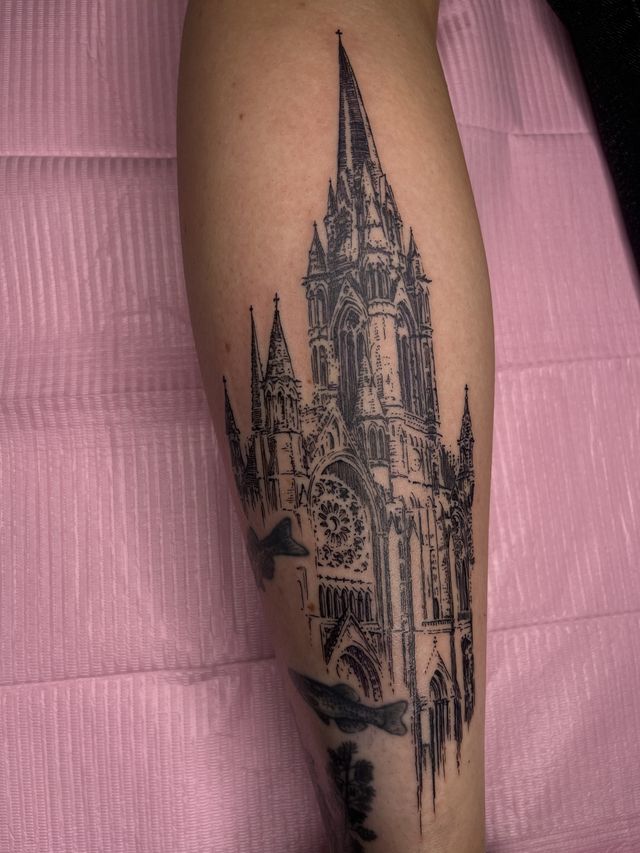Fine line cathedral with a tall central spire, on a forearm.